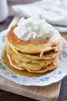 a stack of pancakes topped with whipped cream