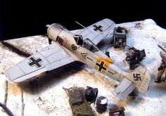 a model airplane sitting on top of a snow covered ground next to other toy planes