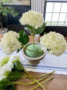 white flowers and green moss in a bowl on a table