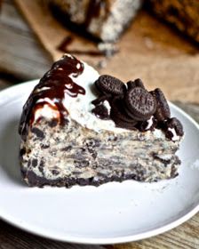 a piece of cake with oreo cookies and cream on it sitting on a white plate