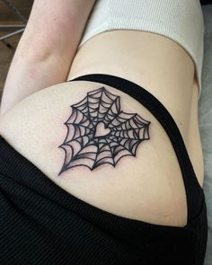 a woman with a spider web tattoo on her thigh