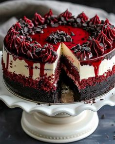 a red velvet cheesecake with chocolate chips on top and one slice missing from it