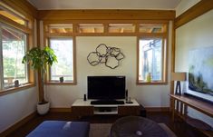 a living room with a flat screen tv sitting on top of a wooden table next to a window