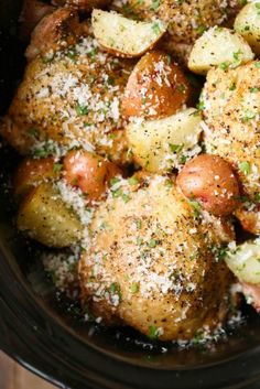 a crock pot filled with potatoes covered in parmesan cheese and seasoning