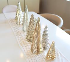 there are many small christmas trees on the table