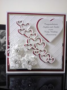 a close up of a greeting card with flowers and hearts on the front, along with an envelope that says congratulations stephen and susan