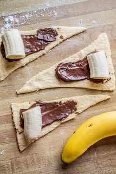 three pieces of chocolate and banana on top of some kind of pastry with the peel cut out