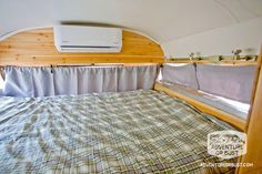 an air conditioner sitting on top of a bed in a room with wood paneling