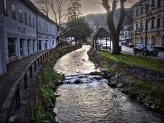 a river running through a small town next to tall buildings