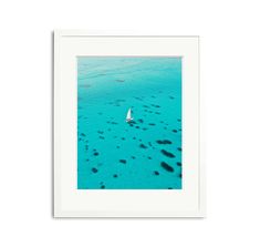 an aerial view of a sailboat in clear blue water