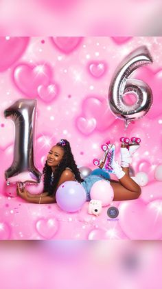 a woman laying on the ground with balloons and confetti in front of her