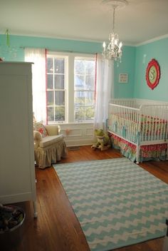 an image of a baby's room with blue walls and white furniture, including a crib