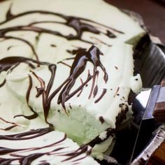 there is a chocolate and white dessert in the bowl with a knife next to it