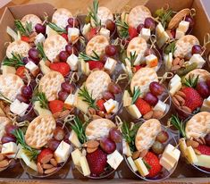 a box filled with crackers, cheeses and fruit on top of each other