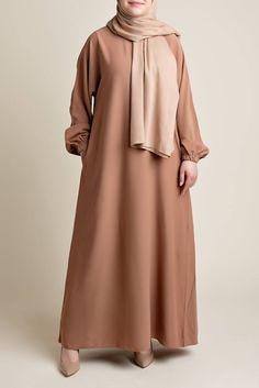 Model wearing a classic Abaya with side pockets in a tan or auburn brown color - Front pose - Momina Hijabs Straight Abaya, Colored Abaya, Jersey Abaya, Hijab Colors, Bamboo Shades, Relaxed Style, Tan Color, Autumn Summer, Silk Satin