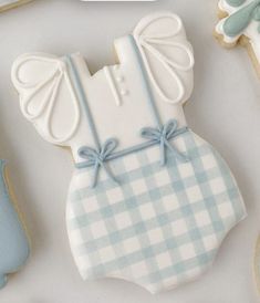 decorated cookies with blue and white designs are displayed on a table next to cookie cutters