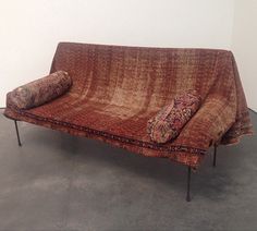 a couch that is sitting on some metal legs