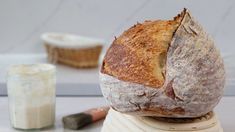 a loaf of bread sitting on top of a counter next to a jar of cream cheese