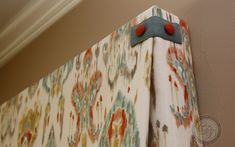 a close up of a curtain with a red button on the end and a blue handle