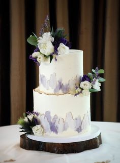 a wedding cake with purple and white flowers