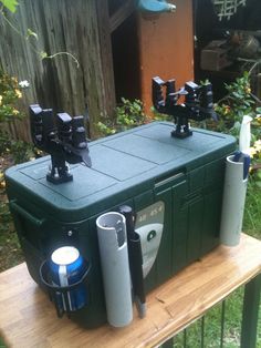 an outdoor cooler sitting on top of a wooden table