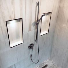 a shower with two square mirrors above it