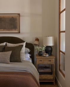 a bedroom with a bed, nightstand and pictures on the wall