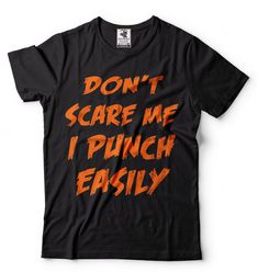 "Halloween Costume Funny T shirt Don't Scare Me I Punch Easily Funny Halloween T shirt Falls T shirt Halloween Party T shirt 100% halloween hit t-shirt.Cool and savage Halloween shirt. This ULTRA COTTON UNISEX T-shirt is made of Pre-shrunk 100% cotton, 6.1-ounce. * Seamless double-needle 7/8\" collar, Double-needle sleeves and hem, Taped neck and shoulders Our T Shirts and Hoodies are Printed by advanced technology Digital Printer on 100% Ultra Cotton tees and hoodies . We use waterbased textile Punk Halloween T-shirt With Text Print, Black Halloween T-shirt With Text Print, Funny Halloween T-shirt With Letter Print, Funny Halloween Shirt With Letter Print, Funny Halloween Letter Print Shirt, Orange Halloween T-shirt With Letter Print, Black Horror T-shirt With Funny Print, Halloween Crew Neck Top With Funny Text, Funny Halloween T-shirt With Text Print