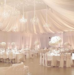 an elegant wedding reception with chandeliers and tables