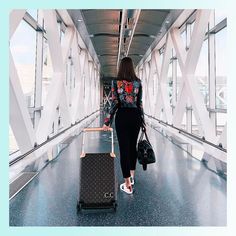 a woman is walking with her luggage through the airport