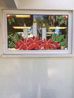 a window decorated with holly and red flowers