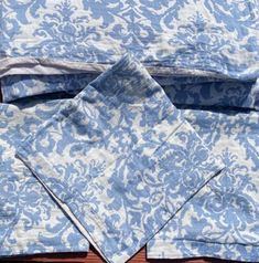 three folded blue and white napkins on top of a wooden table