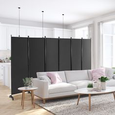 a living room with white furniture and black partitions on the wall behind it,