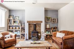 a living room with two couches and a fire place in it's center