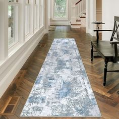 a large blue rug is on the floor in front of a wooden chair and stairs