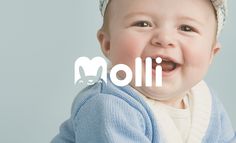 a smiling baby wearing a blue cardigan and white hat with the word molli on it