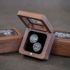 three wooden boxes with different types of buttons in them on a table next to each other