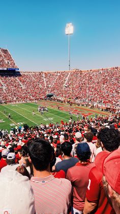 a football stadium filled with lots of people watching the game from the bleachers