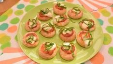 small appetizers are arranged on a green plate