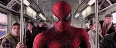 the amazing spider - man is standing in front of people on a subway car with their backs to each other