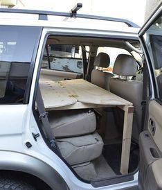 the interior of a vehicle with an open hatchback and table in the passenger side door