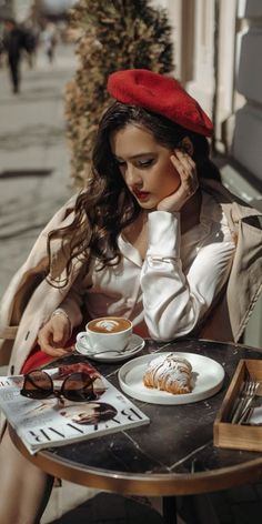 a woman sitting at a table with food on it