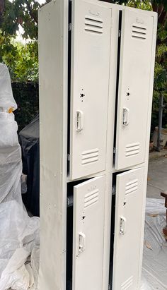 two white lockers sitting next to each other on top of a pile of plastic