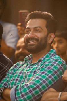 a man with a beard sitting in front of a crowd