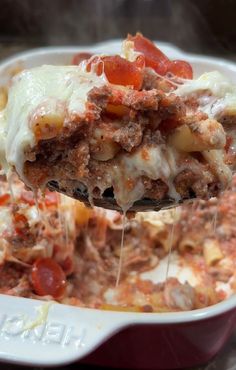 a spoon full of lasagna casserole with meat and cheese on top