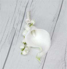 a white flower is laying on a wooden surface