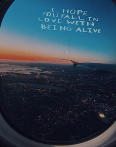 an airplane window with the words i hope you fall in love with being alive written on it