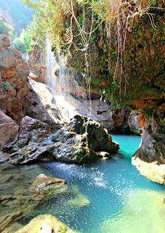 there is a waterfall in the middle of some rocks