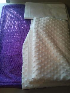 two pieces of white and purple material are laying next to each other on the floor