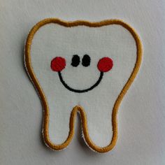 a tooth with a smile embroidered on it